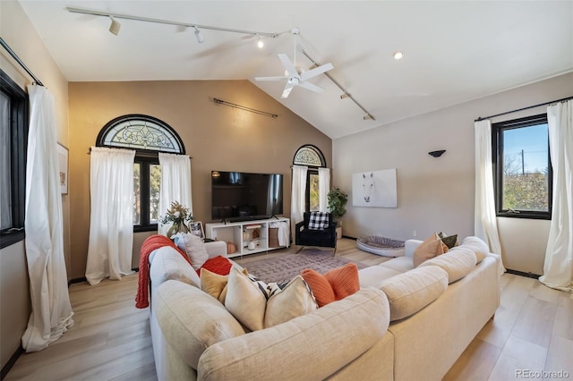 living room with plenty of natural light, rail lighting, and light hardwood / wood-style flooring