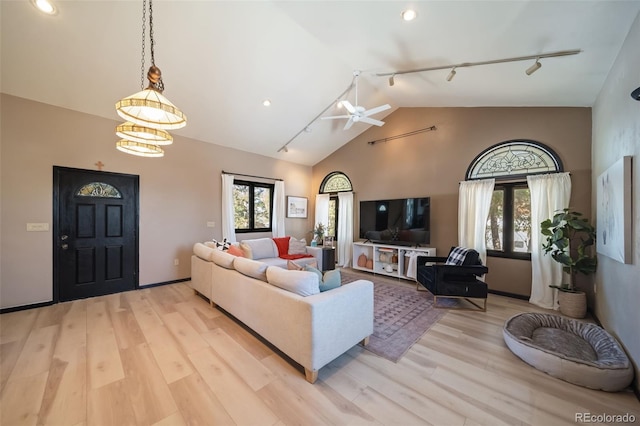 living room featuring high vaulted ceiling, track lighting, light hardwood / wood-style flooring, and ceiling fan