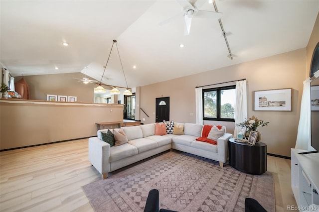 living room featuring ceiling fan, lofted ceiling, and light wood-type flooring