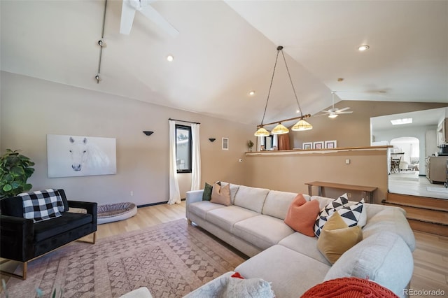 living room featuring ceiling fan, light hardwood / wood-style floors, and lofted ceiling