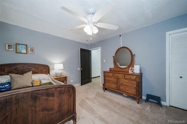 bedroom with ceiling fan, a closet, and light colored carpet