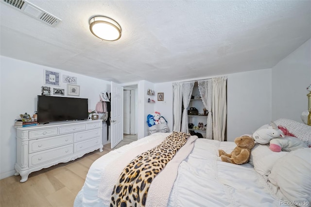 bedroom featuring a textured ceiling and light wood-type flooring