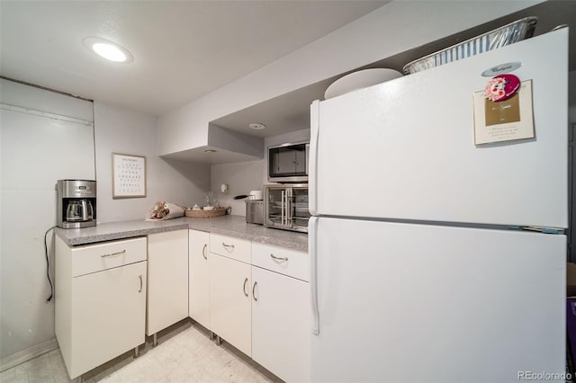 kitchen featuring white cabinets and white refrigerator