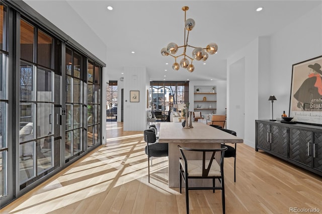 dining space with a notable chandelier and light hardwood / wood-style flooring