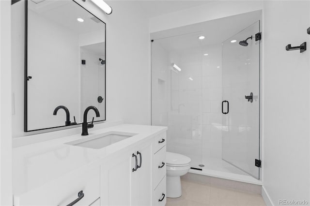 bathroom featuring vanity, toilet, a shower with shower door, and tile patterned flooring