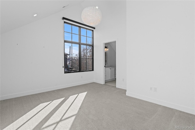 unfurnished room with high vaulted ceiling and light carpet