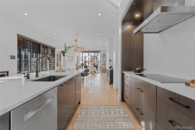 kitchen with pendant lighting, dishwasher, sink, exhaust hood, and black electric stovetop