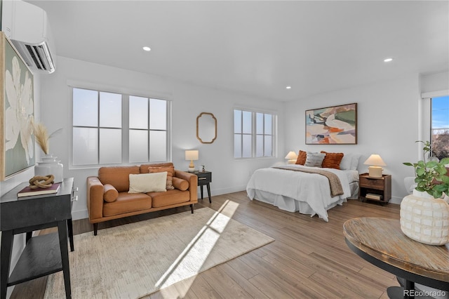 bedroom featuring a wall mounted air conditioner and light hardwood / wood-style flooring