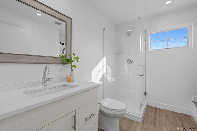 bathroom featuring vanity, toilet, a shower with shower door, and hardwood / wood-style floors