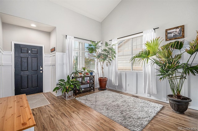 entrance foyer featuring high vaulted ceiling and hardwood / wood-style flooring