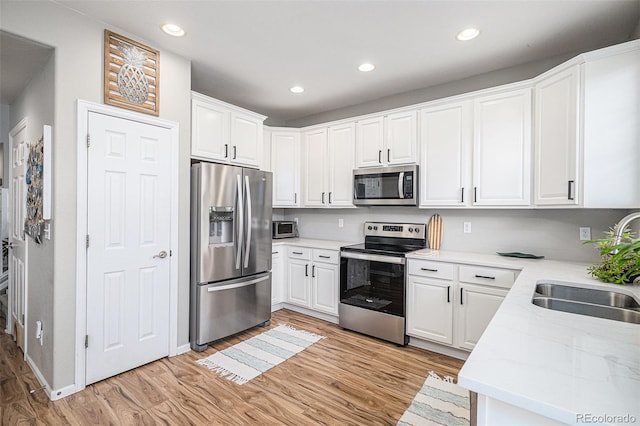 kitchen featuring light hardwood / wood-style floors, white cabinets, stainless steel appliances, and sink