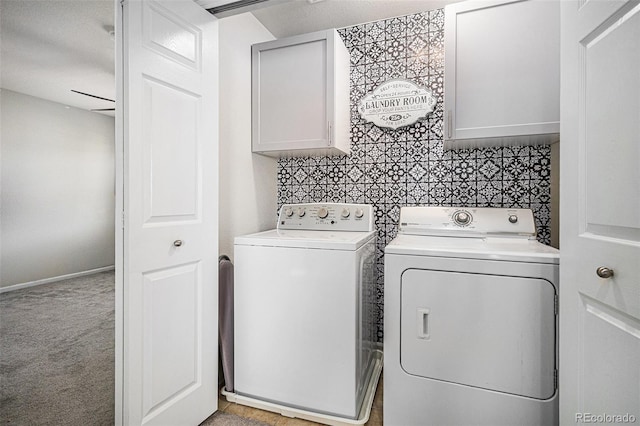 clothes washing area with cabinets, light carpet, and washing machine and dryer