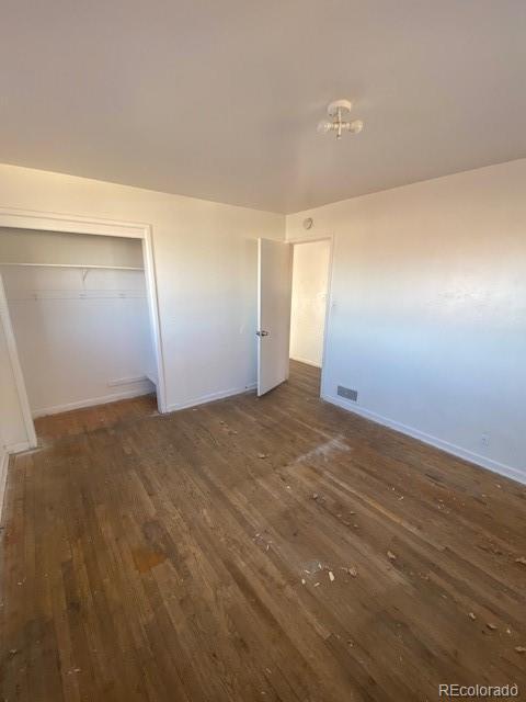 unfurnished bedroom featuring dark wood-type flooring and a closet