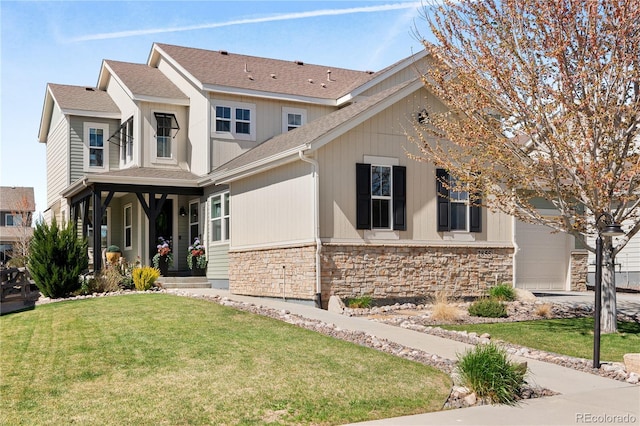2855 Pawnee Creek Dr, Loveland, CO 80538 - view of front of home featuring stone siding, a front lawn, a garage, and a shingled roof