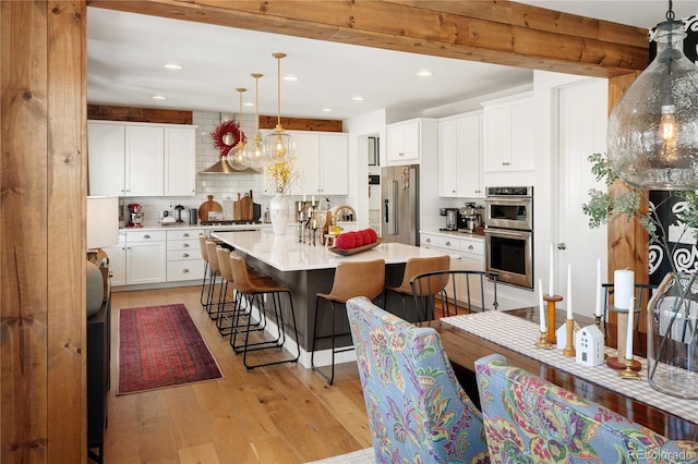 2855 Pawnee Creek Dr, Loveland, CO 80538 - kitchen with stainless steel appliances, tasteful backsplash, light wood finished floors, recessed lighting, and a kitchen breakfast bar