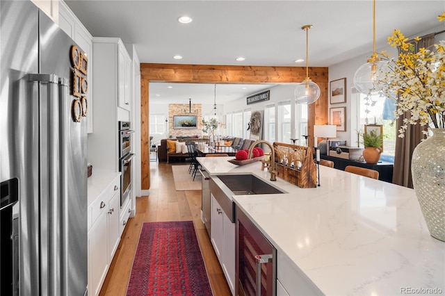 2855 Pawnee Creek Dr, Loveland, CO 80538 - kitchen featuring stainless steel appliances, recessed lighting, light wood-style flooring, open floor plan, and white cabinets