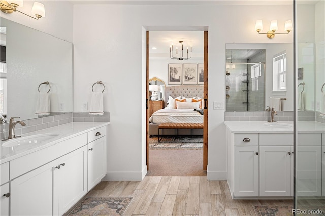 2855 Pawnee Creek Dr, Loveland, CO 80538 - bathroom featuring a stall shower, two vanities, wood finished floors, tasteful backsplash, and connected bathroom