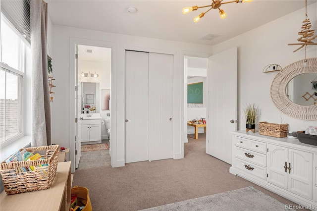 2855 Pawnee Creek Dr, Loveland, CO 80538 - bedroom featuring light colored carpet, a chandelier, connected bathroom, and a closet
