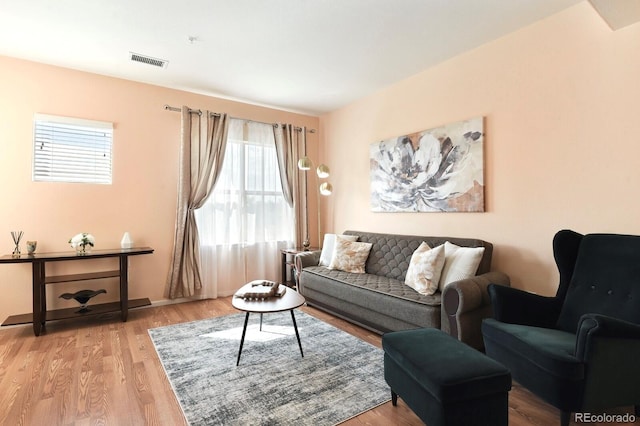 living area featuring visible vents, baseboards, and wood finished floors