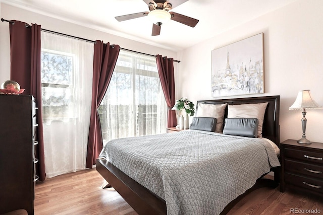 bedroom featuring a ceiling fan, light wood-style flooring, and access to exterior