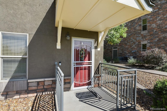 property entrance featuring brick siding and stucco siding