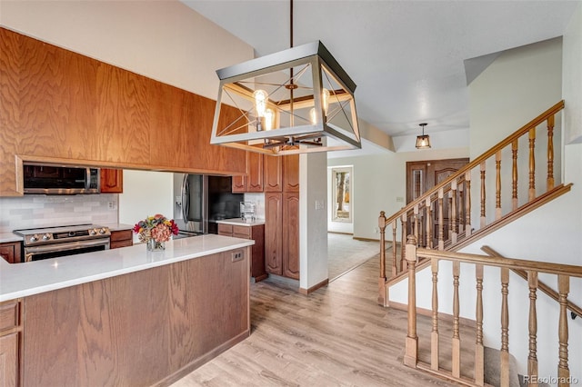 2631 Yorkshire St, Fort Collins, CO 80526 - kitchen featuring appliances with stainless steel finishes, a chandelier, brown cabinetry, backsplash, and light countertops