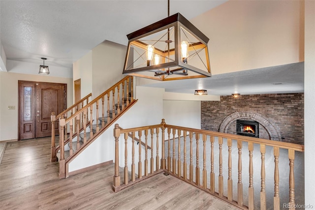 2631 Yorkshire St, Fort Collins, CO 80526 - staircase with wood finished floors, a chandelier, a fireplace, and a textured ceiling