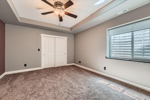 14179 Madison St, Thornton, CO 80602 - unfurnished bedroom featuring a tray ceiling, carpet, a closet, and a ceiling fan
