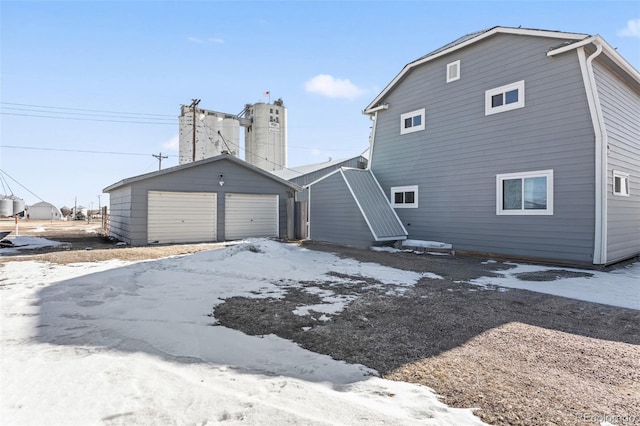48 Elm St, Arriba, CO 80804 - snow covered rear of property featuring a garage and an outdoor structure