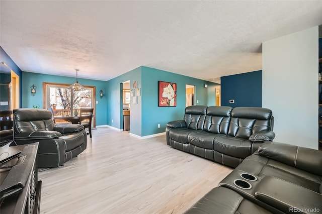 living area with light wood-style floors, baseboards, and a textured ceiling