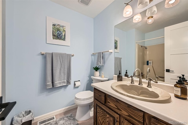 bathroom featuring visible vents, vanity, toilet, and wood finished floors