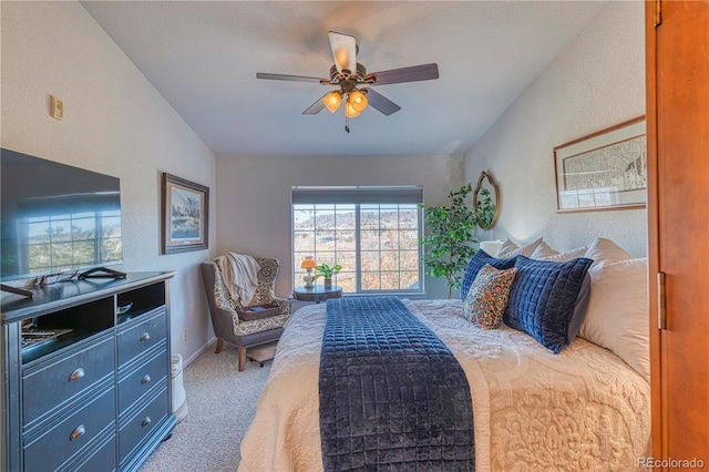 carpeted bedroom with a textured wall, a ceiling fan, and baseboards