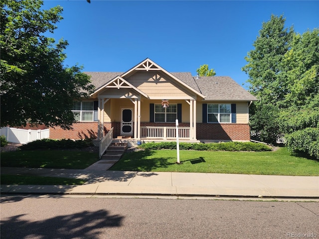 221 Homestead Pkwy, Longmont, CO 80504 - view of front of home featuring brick siding, a front lawn, a porch, and a shingled roof
