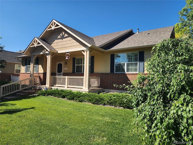 221 Homestead Pkwy, Longmont, CO 80504 - view of front of house featuring brick siding, a front yard, a porch, and a shingled roof