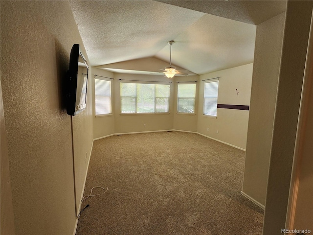 221 Homestead Pkwy, Longmont, CO 80504 - carpeted spare room featuring vaulted ceiling, a textured wall, ceiling fan, and a textured ceiling