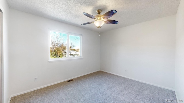 carpeted empty room featuring ceiling fan and a textured ceiling