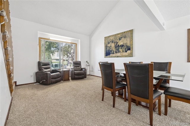 dining space featuring high vaulted ceiling and carpet