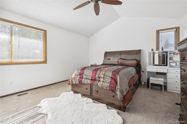 carpeted bedroom featuring vaulted ceiling, multiple windows, ceiling fan, and a textured ceiling