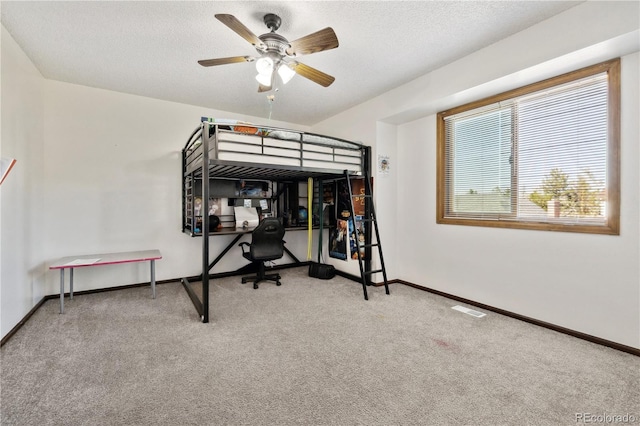 bedroom with a textured ceiling and light colored carpet