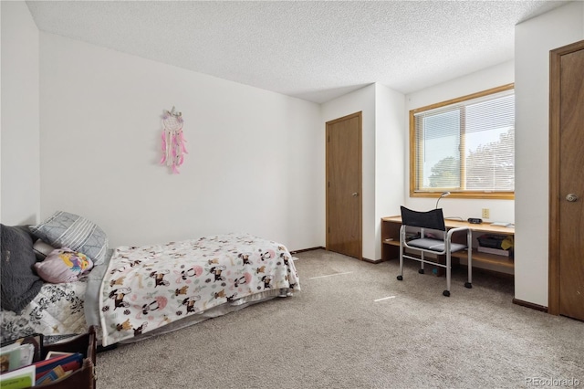 bedroom featuring a textured ceiling and light colored carpet