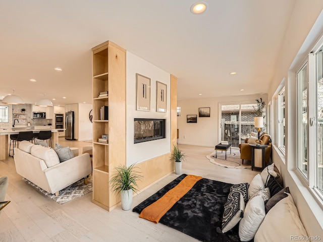 living area with light wood-style flooring, a wealth of natural light, and recessed lighting