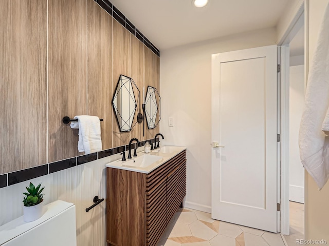 bathroom featuring double vanity, a sink, and tile patterned floors