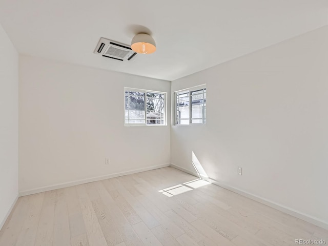 empty room with light wood-type flooring and baseboards