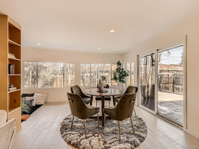 dining area with light wood finished floors, baseboards, and recessed lighting