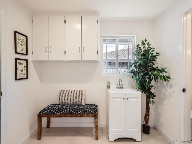 mudroom with a sink and baseboards