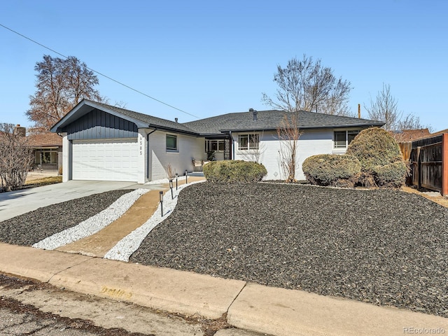 ranch-style home featuring a garage, concrete driveway, fence, board and batten siding, and brick siding