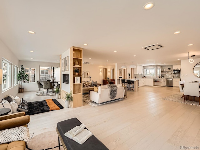 living area featuring light wood-style flooring and recessed lighting