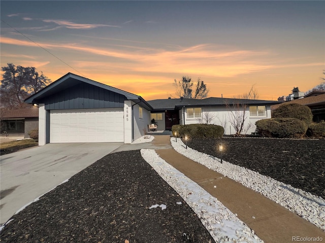 single story home featuring a garage, board and batten siding, and driveway