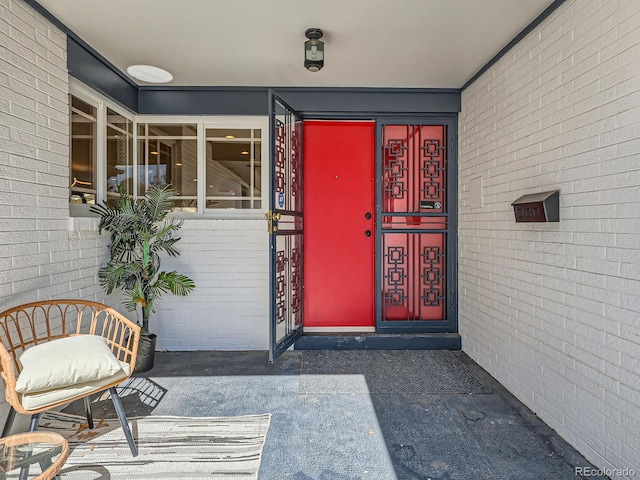 view of exterior entry featuring brick siding