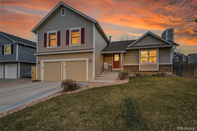 12028 W Aqueduct Dr, Littleton, CO 80127 - view of front facade with concrete driveway, a front lawn, brick siding, a garage, and fence